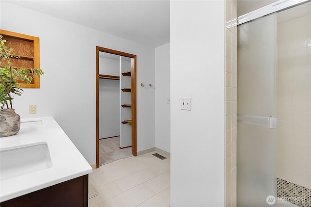 5471 NE Foster Rd, Bainbridge Island, WA 98110 - bathroom with a shower stall, a spacious closet, double vanity, and tile patterned floors