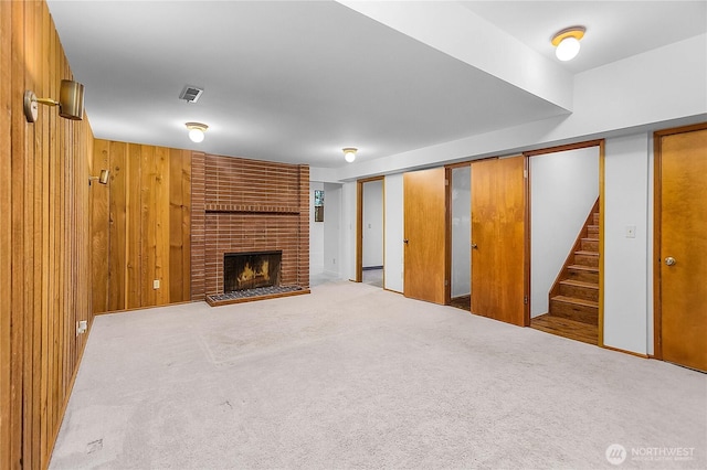 5471 NE Foster Rd, Bainbridge Island, WA 98110 - unfurnished living room featuring a fireplace, stairs, carpet floors, and wood walls