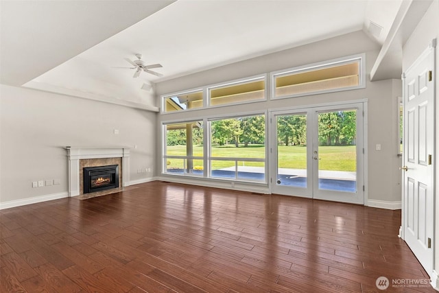 unfurnished living room featuring plenty of natural light, lofted ceiling, and baseboards