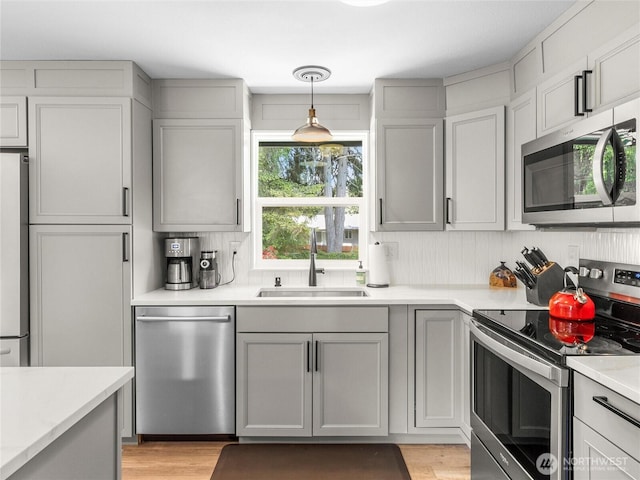 5431 Anton Ct SE, Olympia, WA 98501 - kitchen with appliances with stainless steel finishes, a sink, gray cabinets, light countertops, and light wood-style floors