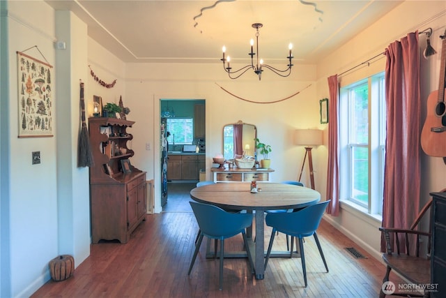 dining room featuring a chandelier, healthy amount of natural light, and wood-type flooring