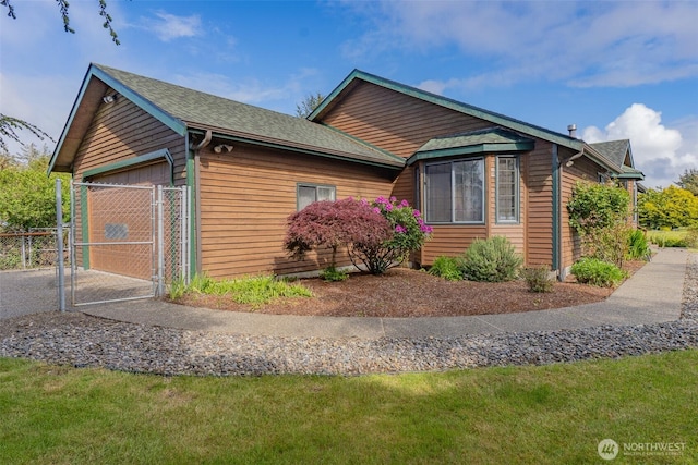 575 Kahkwo Ct SE, Ocean Shores, WA 98569 - view of property exterior featuring a garage, a gate, roof with shingles, and driveway