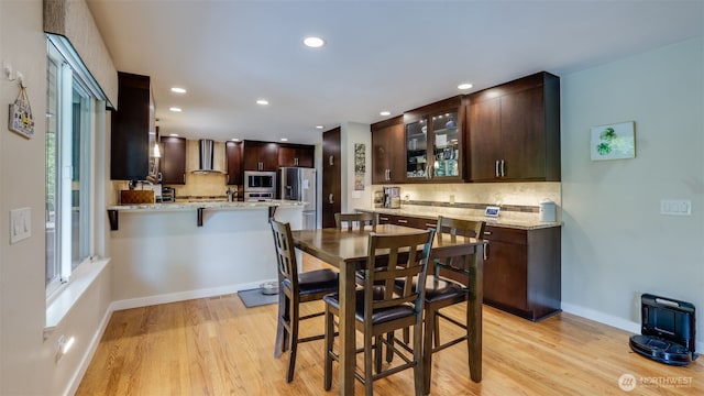 dining room with light wood-style floors, recessed lighting, and baseboards