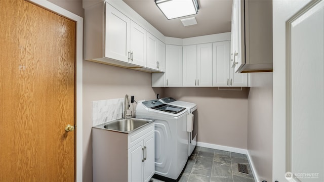 laundry room with washer and clothes dryer, baseboards, and cabinet space