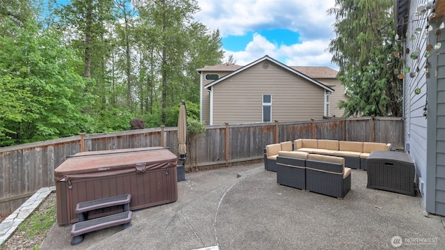 view of patio / terrace with a hot tub, an outdoor living space, and a fenced backyard