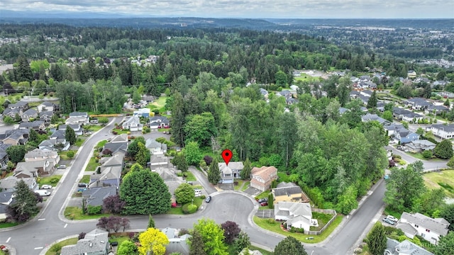 aerial view of property's location with a forest and nearby suburban area