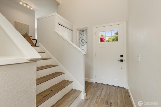 entrance foyer featuring wood finished floors, stairway, and baseboards