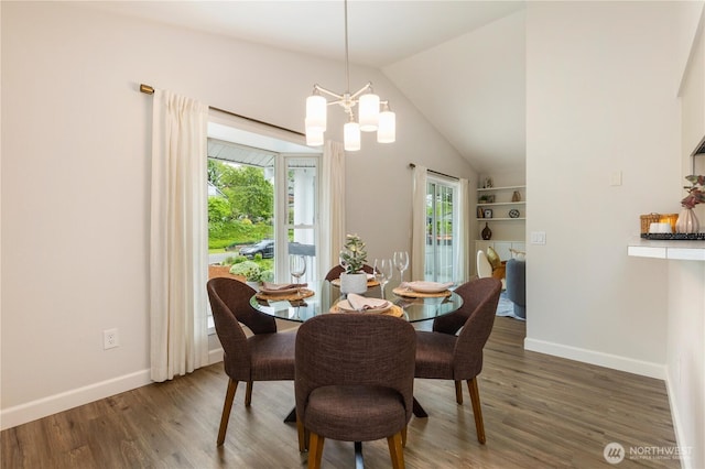 dining area featuring a chandelier, baseboards, plenty of natural light, and vaulted ceiling