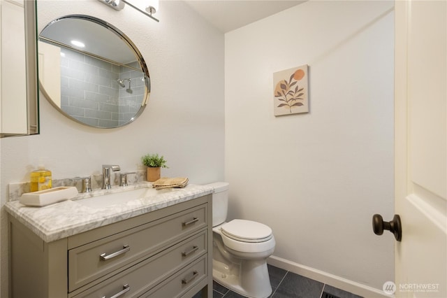bathroom with toilet, tile patterned flooring, vanity, and baseboards