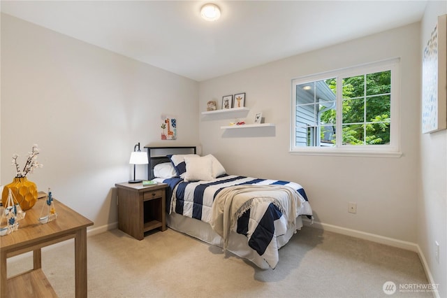 bedroom with baseboards and light carpet