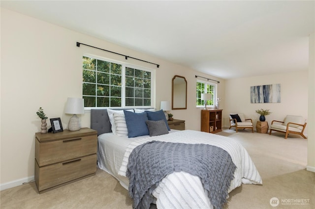 bedroom with light carpet and baseboards