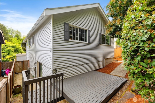 view of home's exterior with a wooden deck and fence