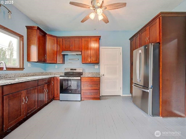 823 D St, Vader, WA 98593 - kitchen with appliances with stainless steel finishes, under cabinet range hood, a sink, a ceiling fan, and light wood finished floors