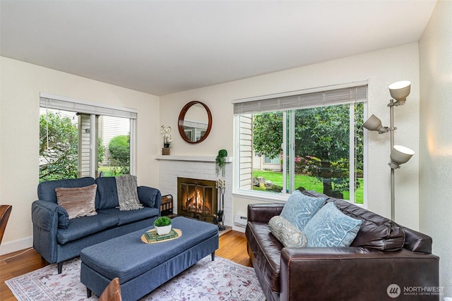 living room with a fireplace, wood finished floors, and a baseboard radiator
