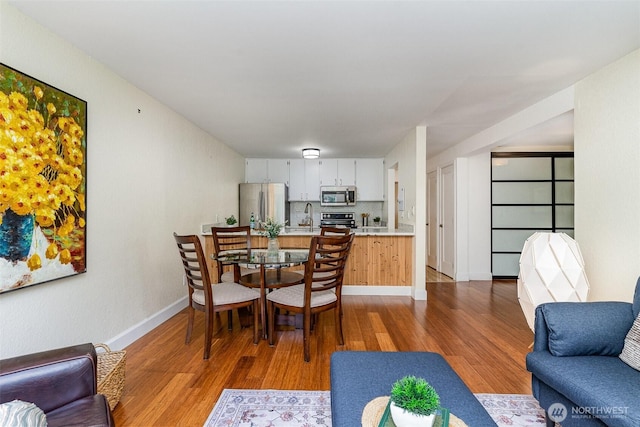 dining room featuring wood finished floors and baseboards