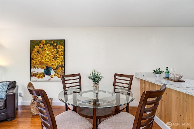 dining space featuring wood finished floors and baseboards