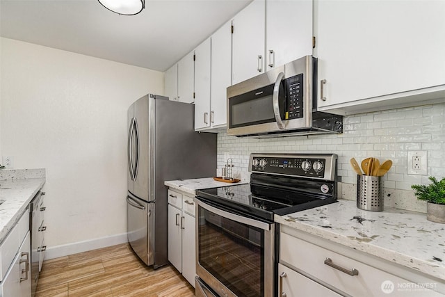 kitchen featuring stainless steel appliances, baseboards, light wood-style flooring, and backsplash