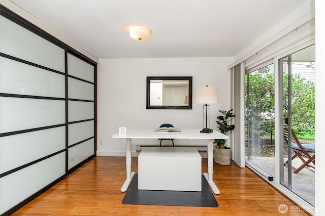 office area with light wood-style flooring and a baseboard heating unit