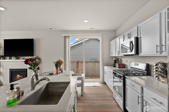 7810 22nd Trl SE, Lacey, WA 98503 - kitchen featuring appliances with stainless steel finishes, a sink, white cabinetry, recessed lighting, and light wood-type flooring