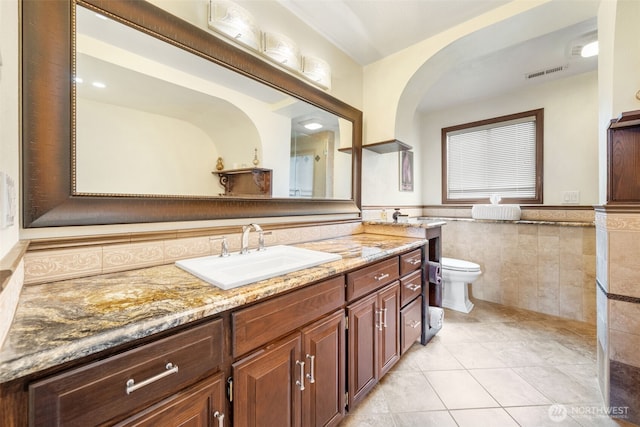 916 Kari Ln, Steilacoom, WA 98388 - full bathroom with vanity, tile patterned flooring, toilet, tile walls, and a wainscoted wall