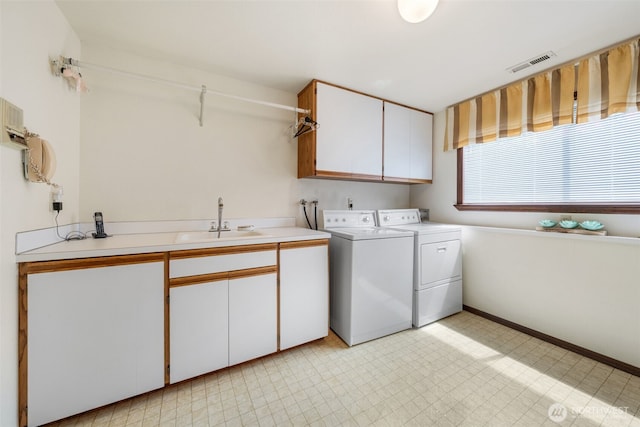 916 Kari Ln, Steilacoom, WA 98388 - laundry area featuring cabinet space, washer and clothes dryer, light floors, and baseboards