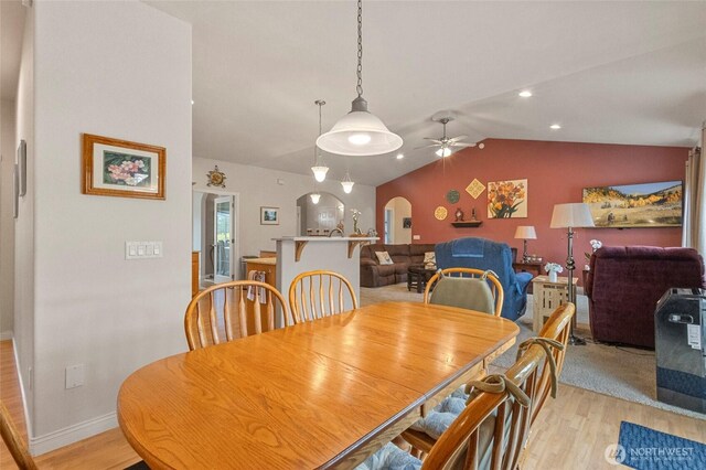2557 Captains Ct, Ferndale, WA 98248 - dining room featuring light wood-type flooring, arched walkways, a ceiling fan, lofted ceiling, and baseboards