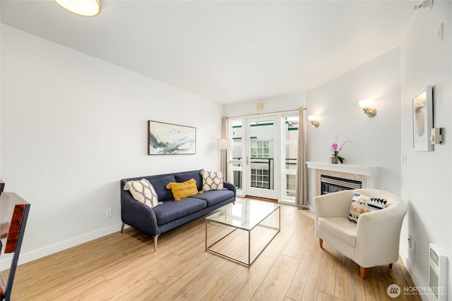 2331 42nd Ave SW Unit 403, Seattle, WA 98116 - living area with light wood finished floors, a tile fireplace, and baseboards