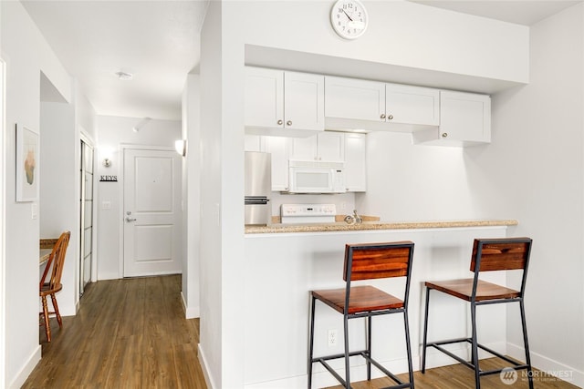 2331 42nd Ave SW Unit 403, Seattle, WA 98116 - kitchen with white microwave, freestanding refrigerator, range, and dark wood-type flooring