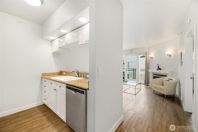 2331 42nd Ave SW Unit 403, Seattle, WA 98116 - kitchen featuring dishwasher, a sink, light wood-type flooring, baseboards, and recessed lighting