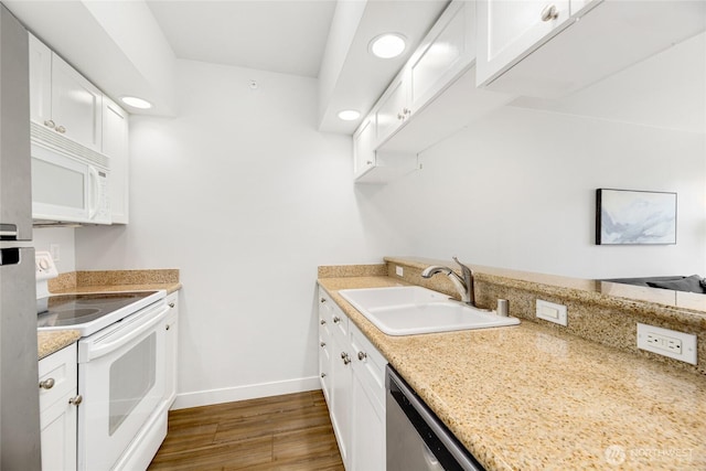 2331 42nd Ave SW Unit 403, Seattle, WA 98116 - kitchen featuring white appliances, a sink, wood finished floors, baseboards, and white cabinetry