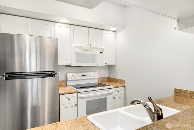 2331 42nd Ave SW Unit 403, Seattle, WA 98116 - kitchen with white appliances, a sink, white cabinetry, and light countertops