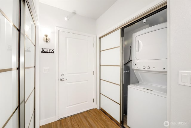 2331 42nd Ave SW Unit 403, Seattle, WA 98116 - laundry area with stacked washer / dryer and light wood-style flooring