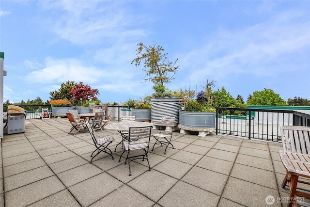 2331 42nd Ave SW Unit 403, Seattle, WA 98116 - view of patio featuring a grill, outdoor dining area, and fence