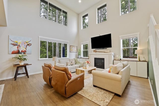 4471 Hales Ct SW, Port Orchard, WA 98367 - living room featuring a towering ceiling, light wood finished floors, a glass covered fireplace, healthy amount of natural light, and recessed lighting