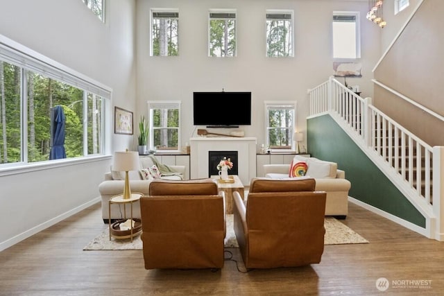 4471 Hales Ct SW, Port Orchard, WA 98367 - living room featuring a towering ceiling, plenty of natural light, wood finished floors, baseboards, and a fireplace