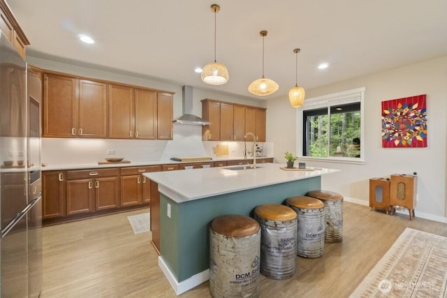 4471 Hales Ct SW, Port Orchard, WA 98367 - kitchen featuring wall chimney range hood, a sink, light wood-type flooring, brown cabinets, and light countertops