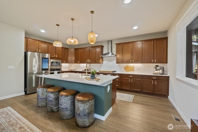 4471 Hales Ct SW, Port Orchard, WA 98367 - kitchen with appliances with stainless steel finishes, wall chimney exhaust hood, wood finished floors, a sink, and light countertops