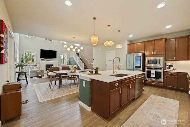 4471 Hales Ct SW, Port Orchard, WA 98367 - kitchen featuring appliances with stainless steel finishes, light countertops, a sink, wood finished floors, and recessed lighting