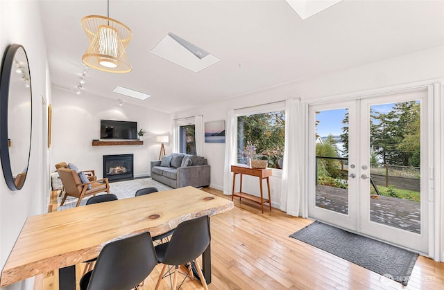 2920 Cedar Ave, Lummi Island, WA 98262 - dining space featuring a skylight, a glass covered fireplace, plenty of natural light, and light wood-style flooring