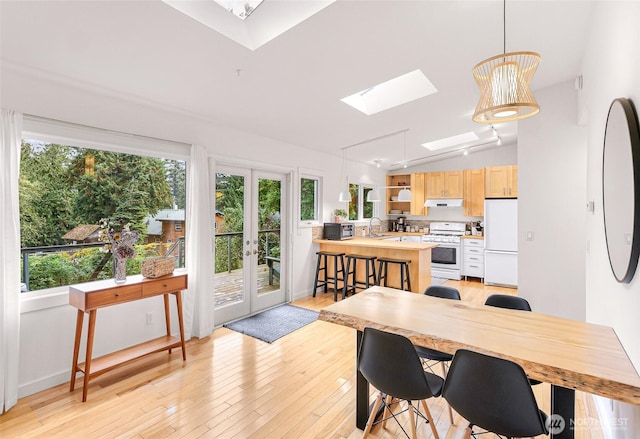 2920 Cedar Ave, Lummi Island, WA 98262 - dining room featuring a skylight, light wood-style floors, french doors, and vaulted ceiling