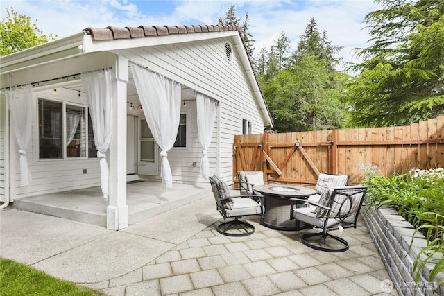 view of patio / terrace with a fire pit, fence, and a gate