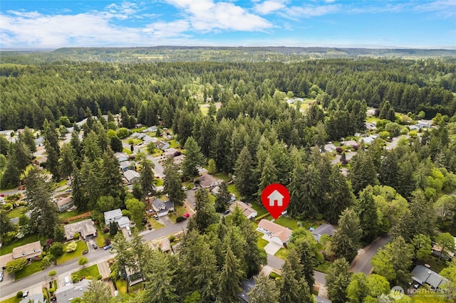aerial view of property's location with a heavily wooded area and nearby suburban area