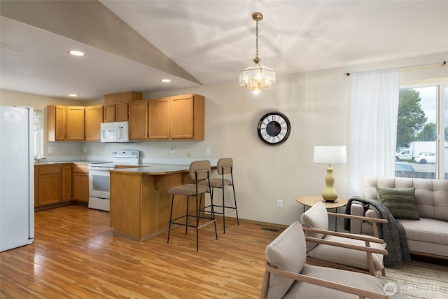 463 Rohrer Loop, Sedro Woolley, WA 98284 - kitchen with white appliances, open floor plan, a peninsula, a kitchen bar, and light wood-style floors