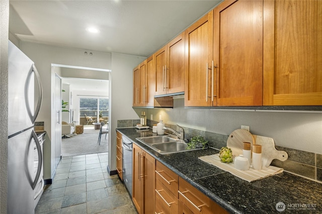 1504 Aurora Ave N Unit 407, Seattle, WA 98109 - kitchen featuring appliances with stainless steel finishes, brown cabinetry, recessed lighting, dark stone countertops, and dark carpet