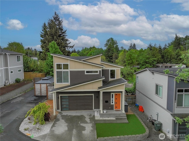 2311 S 135th Ln, Seattle, WA 98168 - view of front of property with concrete driveway, board and batten siding, an attached garage, and fence