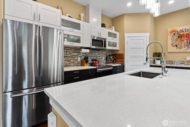2311 S 135th Ln, Seattle, WA 98168 - kitchen featuring stainless steel appliances, a sink, tasteful backsplash, white cabinetry, and recessed lighting