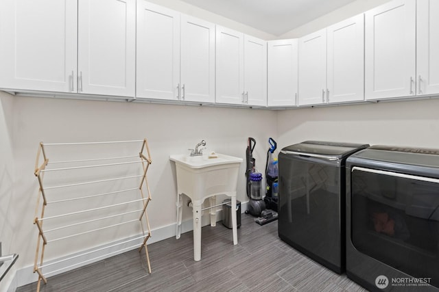 2311 S 135th Ln, Seattle, WA 98168 - washroom featuring independent washer and dryer, cabinet space, and baseboards