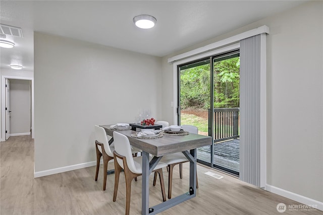 dining space featuring light wood-style floors and baseboards