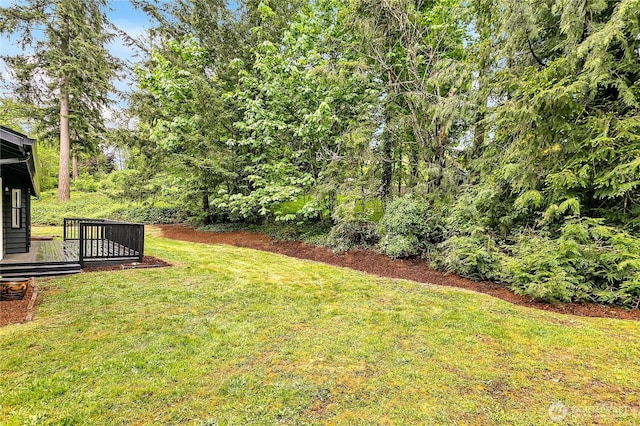 view of grassy yard with a deck