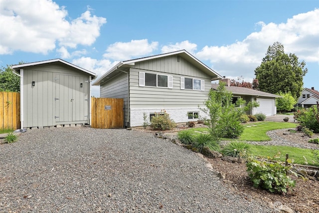view of home's exterior featuring fence, board and batten siding, an outbuilding, and a storage shed